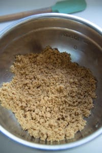 graham cracker crust mixture in a stainless steel bowl