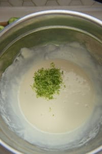 key lime pie filling with lime zest in a large stainless steel bowl